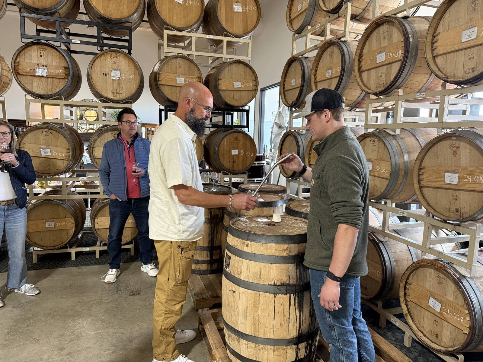 Drawing a taste straight from the barrel with a wine thief