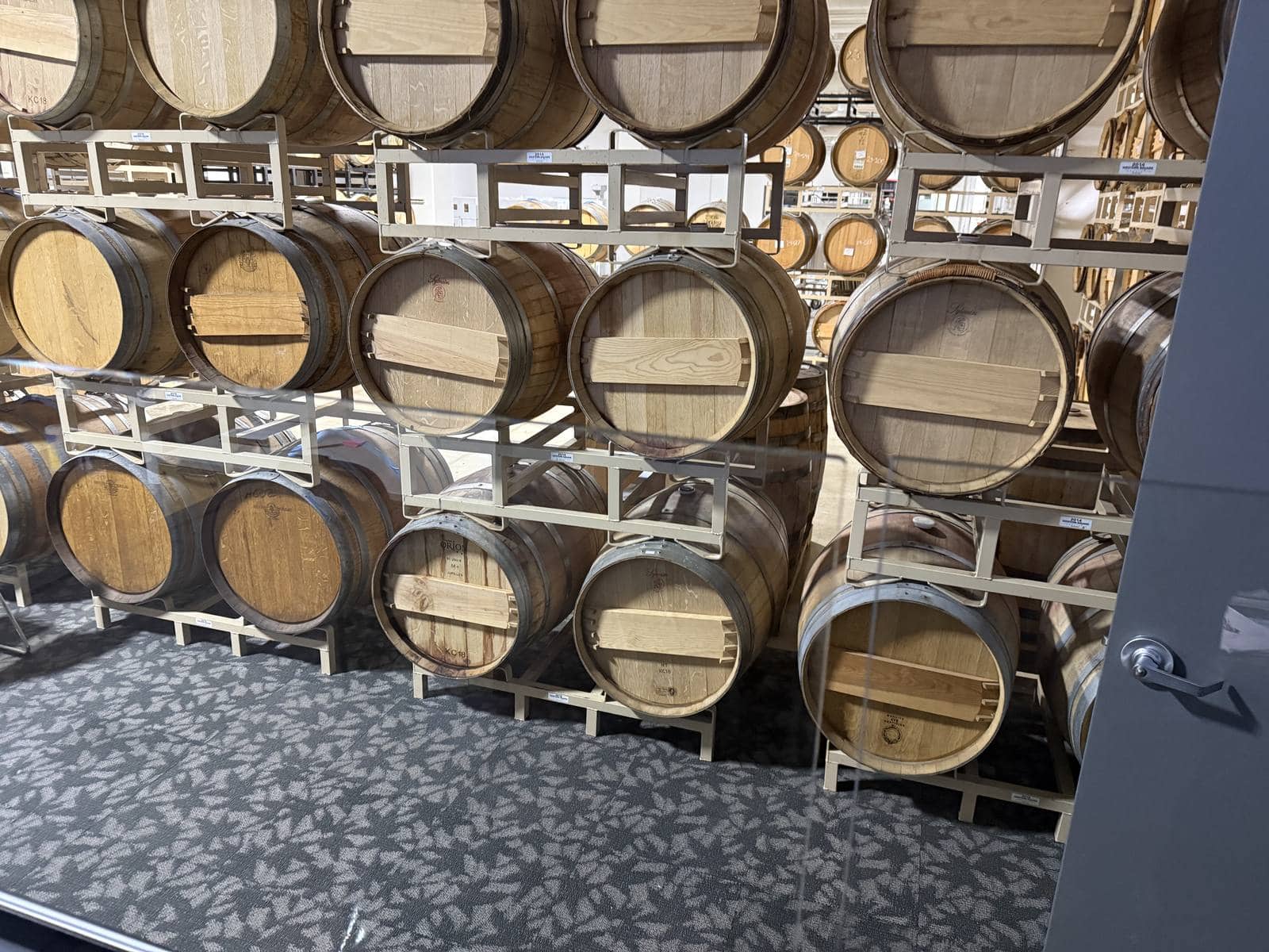 A wall of oak barrels aging on numbered racks